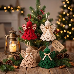 May include: A set of four crocheted angel ornaments in red, cream, beige, and dark green. Each angel features a round head, lace-style wings, and a small ribbon bow at the neck. A brown paper tag attached to the green angel reads Handmade Christmas Angels - Set of 4.