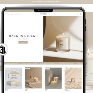 May include: A tablet screen displaying a website for Dewberry, featuring a banner with the text BACK IN STOCK! and a lit candle labeled NUR. Below, a grid shows various candles and soap products, including Coconut Milk & Lime, with some items marked as sold out.