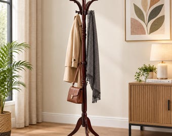 May include: A dark brown wooden coat rack with a central pole, multiple curved hooks at the top, and a tripod base. The rack holds a beige trench coat, a grey patterned scarf, and a brown leather handbag hanging from the hooks.