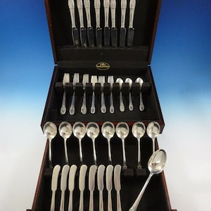May include: A set of Reed & Barton sterling silver flatware in a wooden box. The set includes knives, forks, spoons, and butter knives.
