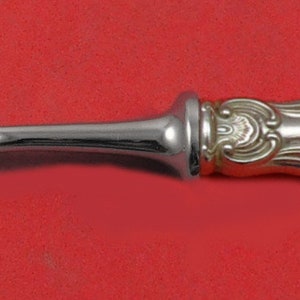 May include: A silver fork with an ornate handle. The handle is decorated with a swirling pattern.