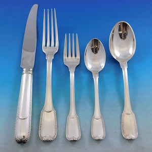 May include: A set of five silver-plated flatware pieces, including a knife, fork, and three spoons. The pieces have a beaded pattern on the handles and a simple, elegant design.