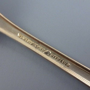 Puede incluir: Primer plano de la parte posterior de una cuchara de plata con la inscripci&oacute;n "Westmoreland Sterling" en el mango.