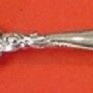 May include: A silver serving fork with a twisted handle and a decorative scroll design at the end.