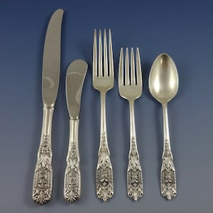 Puede incluir: Cinco piezas de cubiertos de plata, que incluyen un cuchillo para mantequilla, un cuchillo para cenar, un tenedor para cenar, un tenedor para ensalada y una cucharita. Los mangos son ornamentados y presentan un dise&ntilde;o floral.