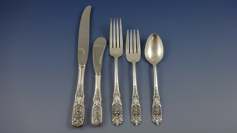 Puede incluir: Cinco piezas de cubiertos de plata, que incluyen un cuchillo para mantequilla, un cuchillo para cenar, un tenedor para cenar, un tenedor para ensalada y una cucharita. Los mangos son ornamentados y presentan un dise&ntilde;o floral.