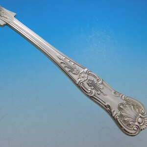 May include: Close-up of the ornate handle of a silver fork. The handle is decorated with a floral design and has a polished finish.