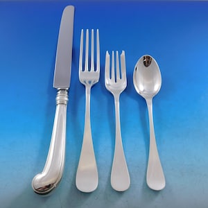 May include: A set of four silver-plated flatware pieces, including a knife, fork, and two spoons, on a blue background.