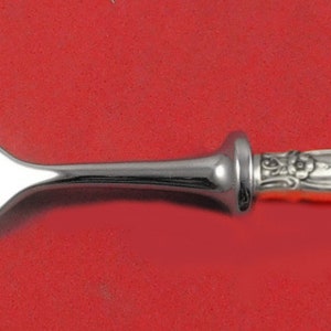 May include: A silver fork with an ornate handle. The fork has four tines and a polished finish.
