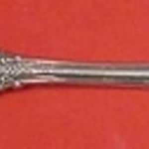 May include: A silver serving fork with a twisted handle and an ornate design. The fork has two prongs and a decorative handle.