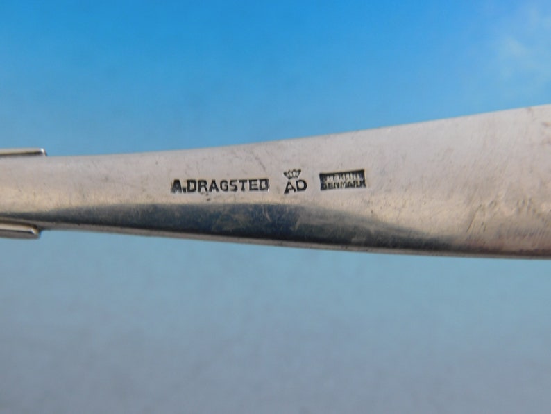 Puede incluir: Primer plano de la parte inferior de una pieza de cubiertos de plata con la inscripci&oacute;n "A. Dragasted AD Denmark".