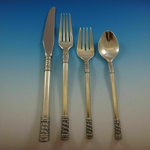 May include: A set of four silver-plated flatware pieces, including a knife, fork, and two spoons. The handles are decorated with a woven pattern.