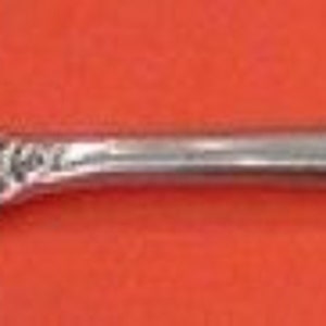 May include: A silver fork with a twisted handle and a decorative end. The fork is designed for serving food.