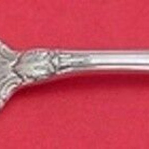 May include: A silver cake fork with a twisted handle and ornate design. The fork has two tines and a decorative handle.