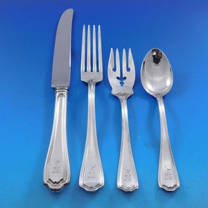 May include: Four pieces of silver flatware, including a knife, fork, salad fork, and a spoon. The flatware has a simple, elegant design with a rounded handle and a polished finish.
