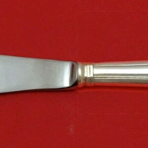 May include: A silver butter knife with a plain blade and a fluted handle.