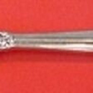 May include: A silver fork with a decorative handle. The handle is ornate and features a floral design. The fork has two tines.