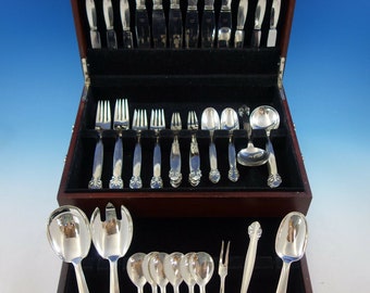 May include: A set of silver flatware in a wooden box. The flatware includes knives, forks, spoons, and serving pieces. The box is lined with black velvet.