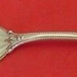 May include: A silver serving fork with a twisted handle and ornate design. The fork has two prongs and a decorative handle.