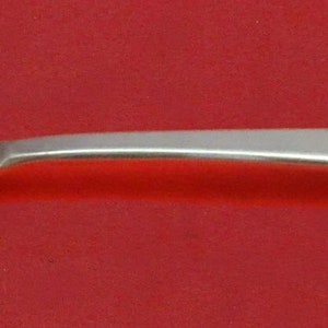 May include: A silver spoon with a decorative, openwork design on the bowl. The spoon has a long, slender handle.