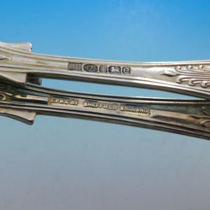 May include: Close-up of the underside of two silver spoons. The spoons are marked with "EPNS" and "Sheffield England". One spoon is also marked with "U 925 XE".