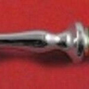 May include: A silver fork with a gold-plated handle. The handle has a floral design.