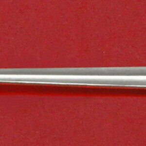 May include: A silver serving spoon with an ornate handle and a pierced bowl. The bowl has a decorative design of a stylized flower.