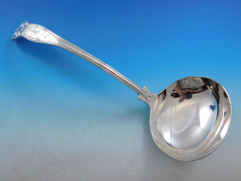 May include: A silver serving ladle with a decorative handle and a polished bowl.