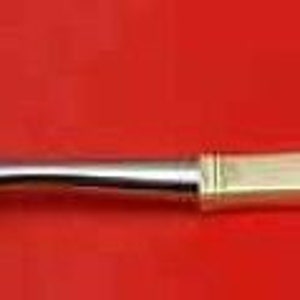 May include: A silver pasta server with a decorative, openwork design and a gold-plated handle.