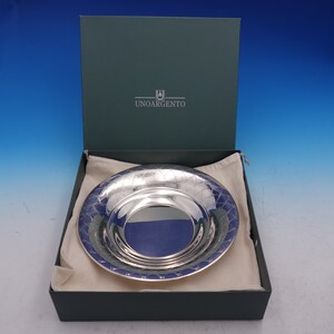 May include: A silver serving dish with a decorative pattern, in a green box with the text "UNOARGENTO" on the lid.