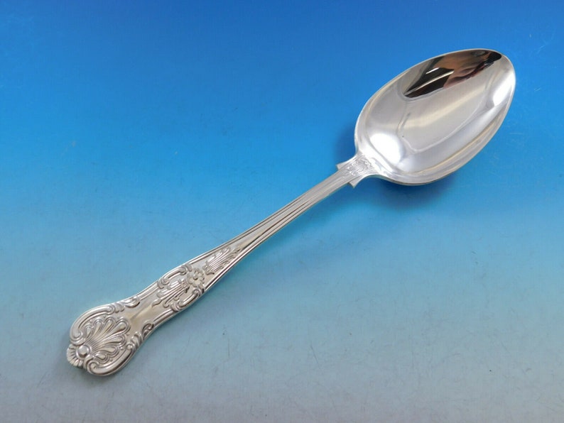 May include: A silver spoon with an ornate handle and a polished bowl. The handle features a detailed floral design.