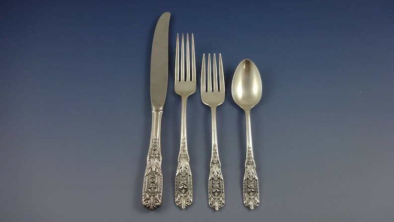 Puede incluir: Un juego de cuatro piezas de cubiertos plateados, que incluye un cuchillo, dos tenedores y una cuchara. Los mangos son ornamentados y presentan un dise&ntilde;o floral.