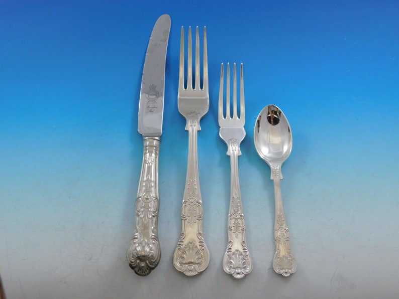 May include: A set of silver flatware, including a knife, fork, and spoon. The handles are ornate and feature a floral design.
