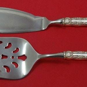 May include: A silver cake server and fork set with ornate handles. The server has a smooth blade and the fork has a decorative, openwork design.