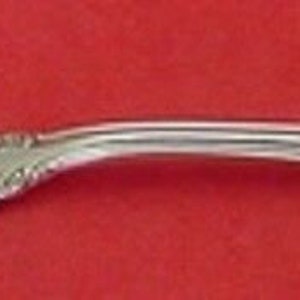 May include: A silver fork with a twisted handle and a decorative, ornate design. The fork has two prongs.
