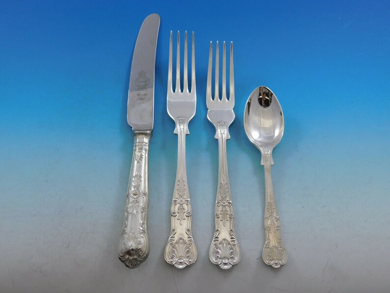May include: A set of four silver-plated flatware pieces, including a knife, two forks, and a spoon. The handles are ornate and feature a floral design.