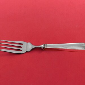 May include: A silver fork with a simple, elegant design. The handle has a subtle geometric pattern.