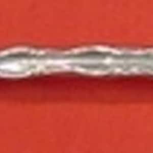 May include: A silver serving fork with a decorative handle and two tines. The tines have a twisted design, and the handle has a floral pattern. The fork is likely made of sterling silver.