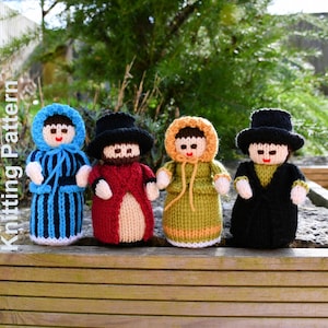 Puede incluir: Cuatro muñecas de punto en fila, cada una con un atuendo único. Las muñecas tienen sombreros negros, capuchas y abrigos en varios colores, incluyendo azul, rojo, verde y negro. El texto "Knitting Pattern" es visible.