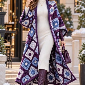 May include: A long, open-front crochet cardigan featuring a patchwork of square motifs in shades of deep purple, light blue, and white. The garment is worn over a cream-colored, ribbed knit turtleneck dress, paired with dark purple knee-high boots.