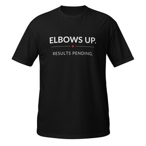 Könnte beinhalten: Ein schwarzes Kurzarm-T-Shirt mit dem weißen Schriftzug ELBOWS UP., gefolgt von einem kleinen roten Ahornblatt-Symbol und dem Text RESULTS PENDING. mittig auf der Brust. Das Kleidungsstück hat einen Rundhalsausschnitt und einen geraden Schnitt.
