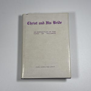 Peut inclure: Un livre relié avec une jaquette blanche présentant le titre Christ and His Bride en lettres gothiques violettes. Sous le titre, le texte indique An Exposition of the Song of Solomon, avec l'auteure Cora Harris MacIlravy en bas.