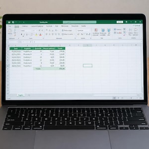 Può includere: Un computer portatile che mostra un foglio di calcolo Microsoft Excel con una tabella intitolata Vendite.xlsx. La tabella contiene colonne per data, prodotto, quantità, prezzo unitario e totale, con righe per Prodotto-A, Prodotto-B e Prodotto-C.