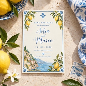 Puede incluir: Una tarjeta Save the Date rectangular con borde azul, ilustraciones de ramas de limón y una pintura de paisaje costero. El texto dice: Save the Date for the wedding of Sofia and Marco, 14.06.2026, Amalfi Coast, Italy, Formal invitation to follow.