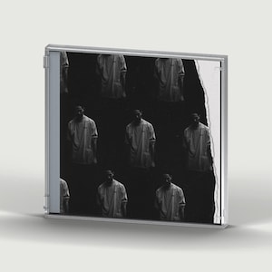 Peut inclure: Un boîtier CD en plastique transparent avec une pochette en noir et blanc. L'illustration présente un motif répétitif d'une personne portant un haut à manches longues sur un fond sombre, avec un bord en papier blanc déchiré.