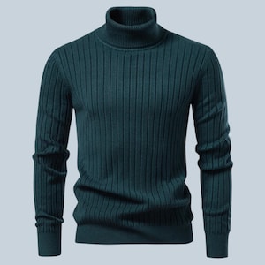 Könnte beinhalten: Ein dunkel-petrolfarbener Langarmpullover mit einer gerippten Strickstruktur am gesamten Körper und an den Ärmeln. Das Kleidungsstück ist mit einem hohen Rollkragen gestaltet und mit gerippten Bündchen an den Ärmeln und am Saum versehen.