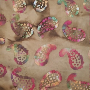May include: A brown fabric with a paisley pattern in shades of pink, green, and brown. The fabric is measured with a yellow ruler that reads "FACTORY FURNITURE".