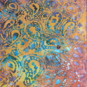 May include: A close-up of a fabric with a batik pattern in shades of blue, orange, yellow, and purple. The fabric has a repeating pattern of circles and swirls. The fabric is measured with a yellow tape measure that reads "FACTORY FURNITURE WORK".