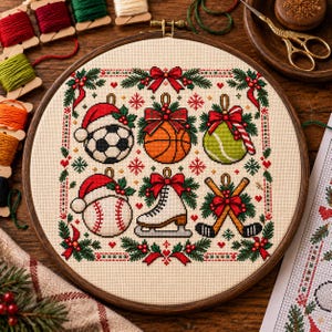 May include: A circular wooden embroidery hoop containing a cross-stitch pattern of six sports-themed Christmas ornaments, including a soccer ball, basketball, tennis ball, baseball, ice skate, and hockey sticks, all decorated with red bows and holly.