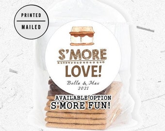 Puede incluir: Una pegatina redonda con una ilustración marrón y blanca de un s'more. El texto de la pegatina dice "S'more Love! Bella & Max 2021". Debajo de la pegatina hay una pegatina más pequeña que dice "Available Option S'more Fun!"